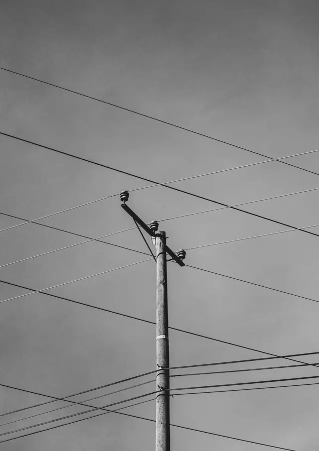 Power lines on a pole against a grey sky